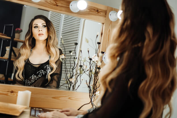 Beautiful woman looking at herself at the dressing table - dark circles under eyes