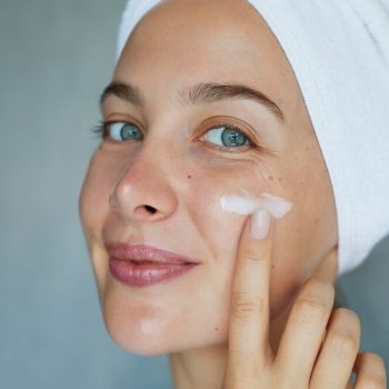 woman applying moisturizer