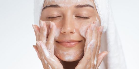 Woman cleansing face