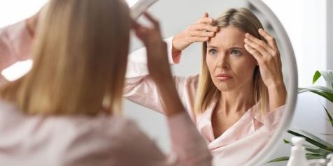 Woman touching stress wrinkles on her forehead